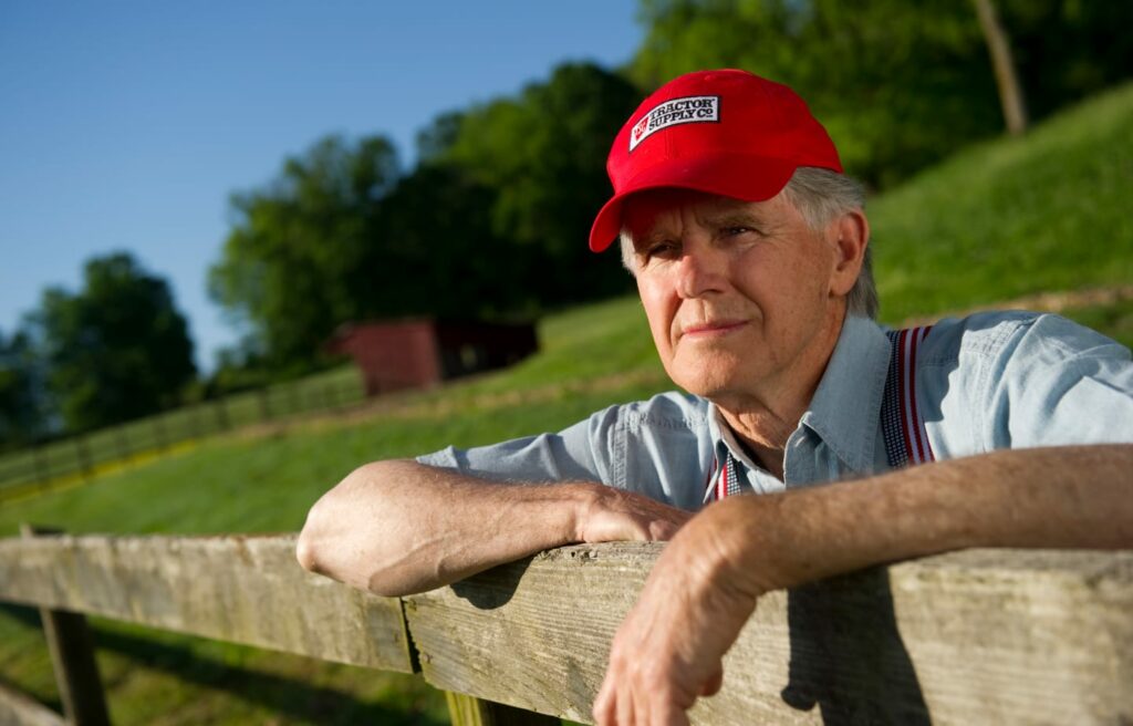 Farmer looking out over field wearing a Tractor Supply Co hat
