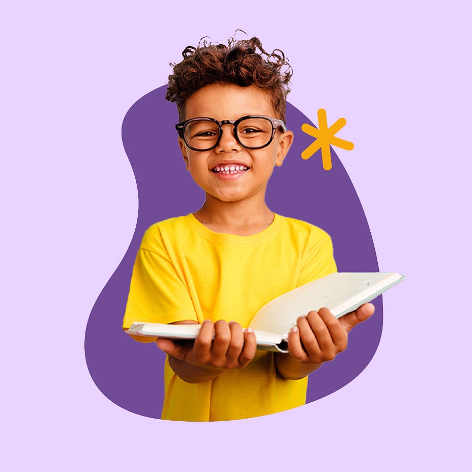 Young boy smiling and holding a book